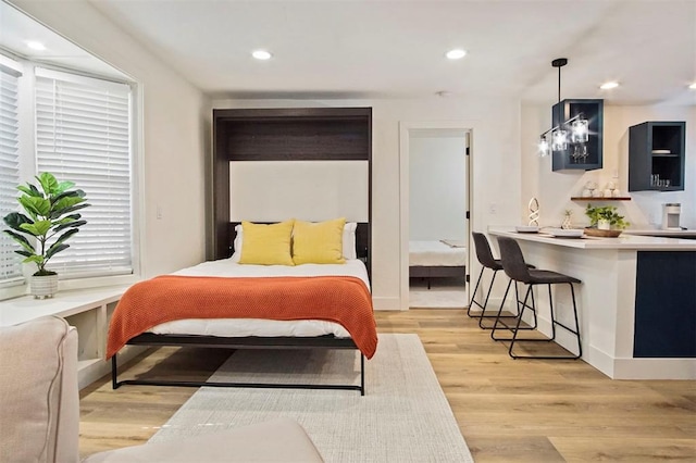 bedroom with a chandelier and light hardwood / wood-style flooring