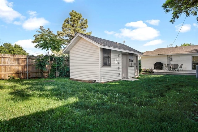 back of property featuring a lawn and an outdoor structure