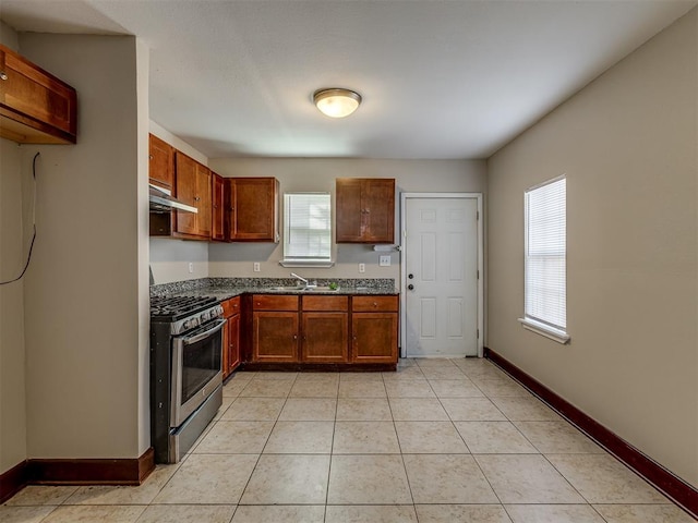 kitchen featuring light tile patterned flooring, gas stove, and sink