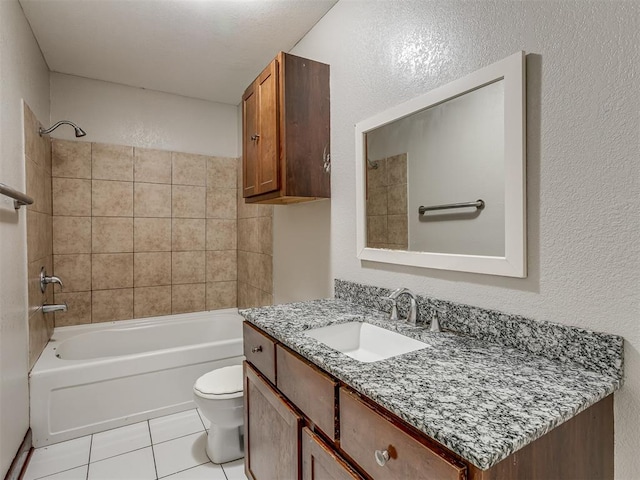 full bathroom with tile patterned floors, vanity, tiled shower / bath, and toilet