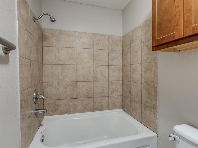 bathroom with tiled shower / bath combo and toilet