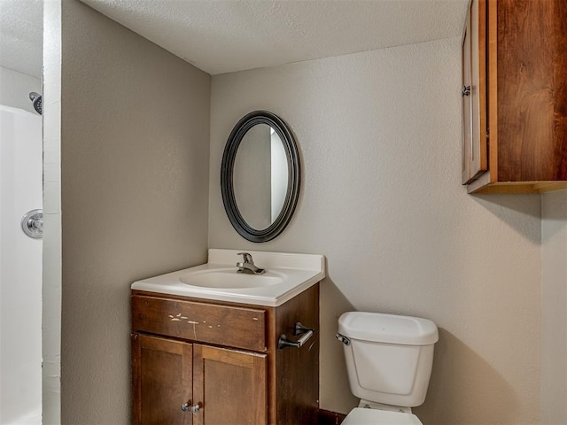 bathroom with vanity, a textured ceiling, and toilet