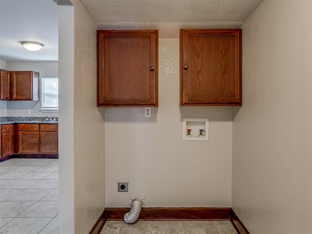 laundry room with hookup for an electric dryer, hookup for a washing machine, light tile patterned floors, and sink