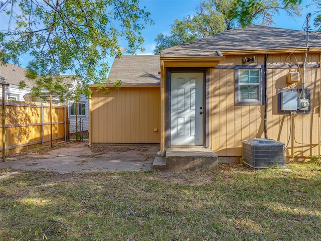 rear view of property with cooling unit and a yard