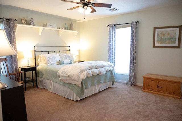 bedroom with baseboards, visible vents, and light colored carpet