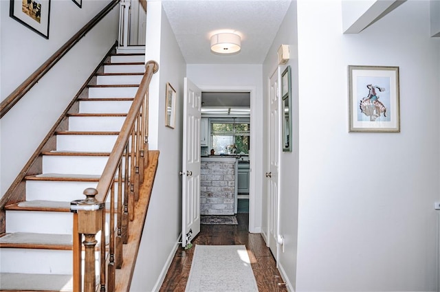 interior space with dark wood-style flooring and baseboards