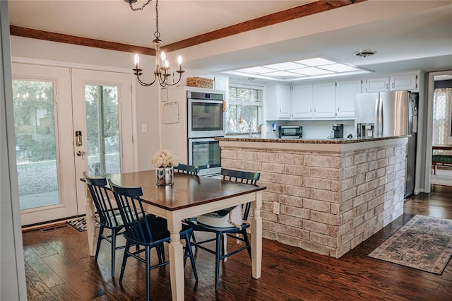 dining area with a toaster, visible vents, dark wood finished floors, and a notable chandelier