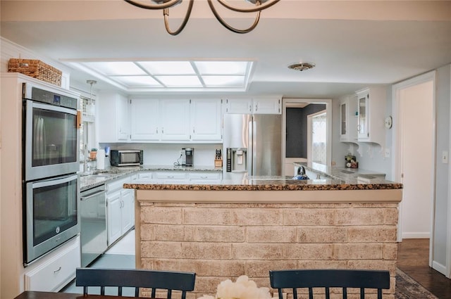 kitchen featuring stainless steel appliances, white cabinets, and glass insert cabinets