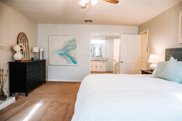 carpeted bedroom featuring visible vents, connected bathroom, baseboards, and ceiling fan