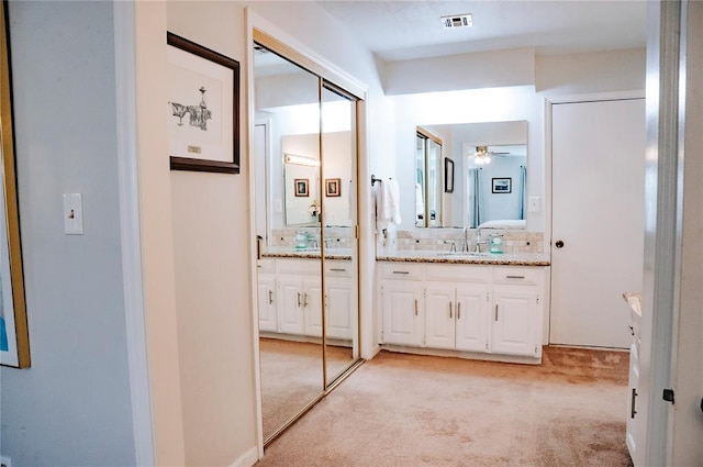 full bath with carpet floors, vanity, visible vents, a ceiling fan, and backsplash