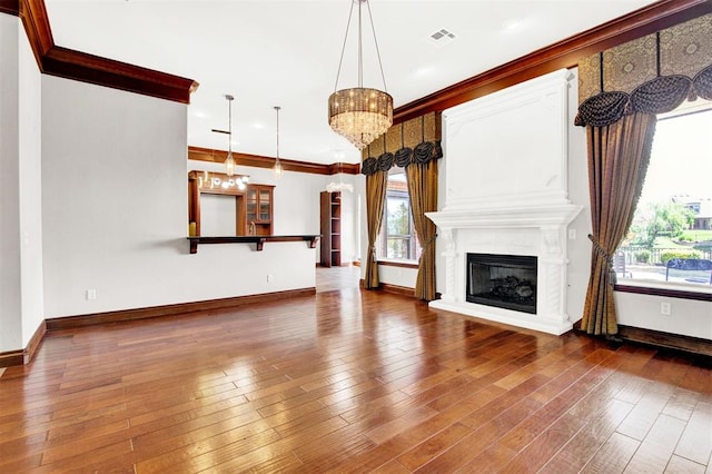 unfurnished living room with hardwood / wood-style floors, a large fireplace, and a wealth of natural light