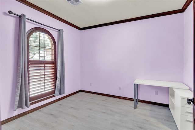 spare room with light wood-type flooring and crown molding