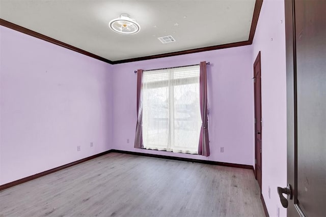 spare room featuring ornamental molding and light hardwood / wood-style flooring