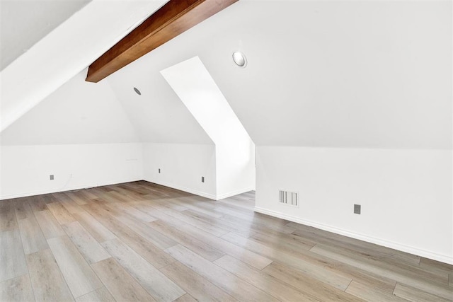 additional living space with lofted ceiling with beams and light hardwood / wood-style floors