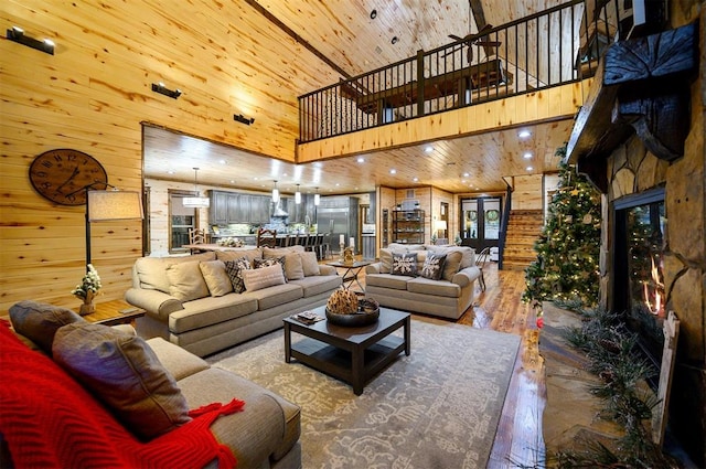 living room featuring hardwood / wood-style floors, wood walls, wood ceiling, and a high ceiling