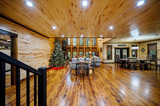 dining area featuring hardwood / wood-style floors, wood walls, wooden ceiling, and french doors