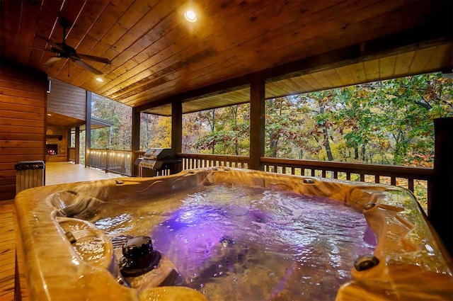 wooden deck featuring ceiling fan, a grill, and a hot tub