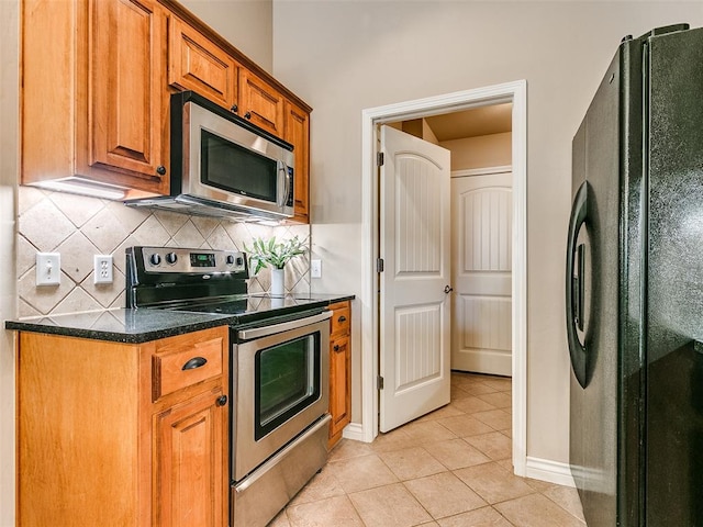 kitchen with light tile patterned flooring, backsplash, and appliances with stainless steel finishes