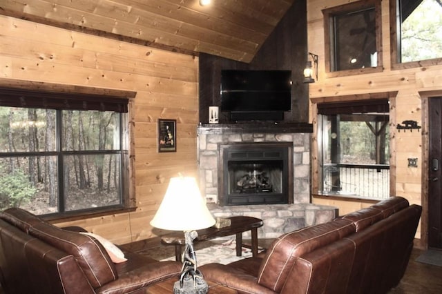 living room with wood walls, a stone fireplace, lofted ceiling, and wood ceiling