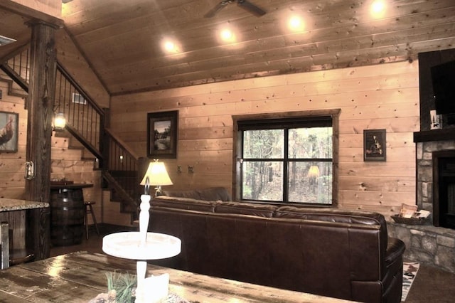 living room featuring a stone fireplace, wooden walls, vaulted ceiling, hardwood / wood-style flooring, and wood ceiling