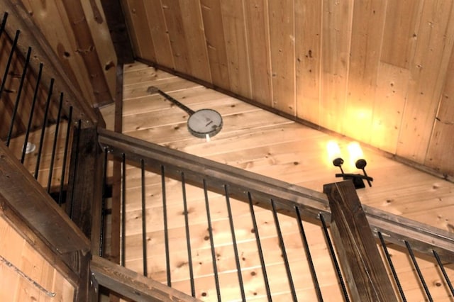 staircase featuring wooden walls