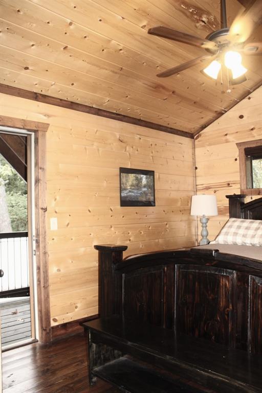 bedroom featuring dark hardwood / wood-style flooring, lofted ceiling, wooden walls, and wooden ceiling