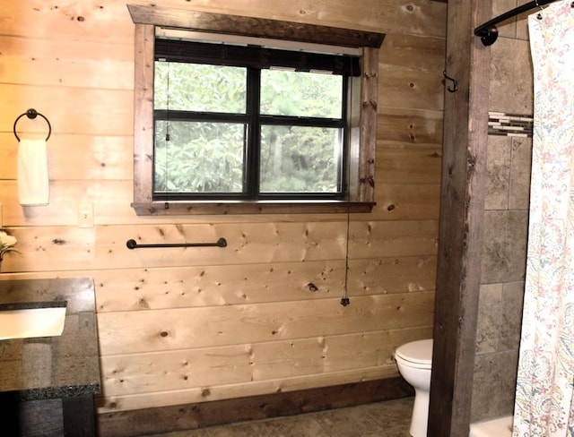 bathroom featuring a shower with curtain, wood walls, and toilet