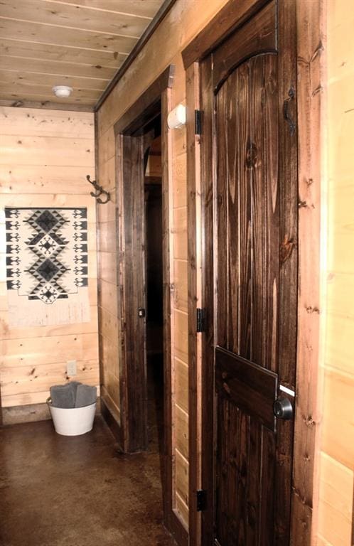 hall featuring wood walls and wooden ceiling