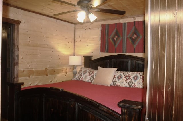 bedroom with ceiling fan and wood walls