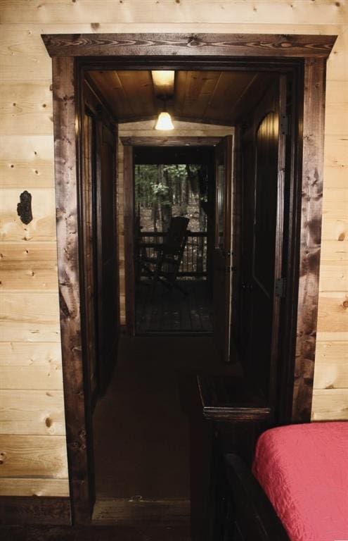 hallway featuring wooden walls and wood ceiling