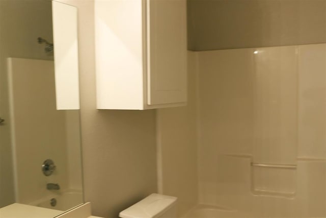 bathroom featuring shower / bath combination and toilet