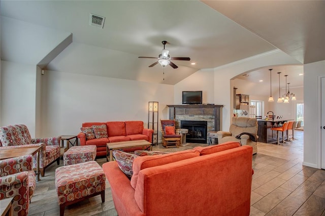 living room with ceiling fan with notable chandelier, light hardwood / wood-style floors, lofted ceiling, and crown molding