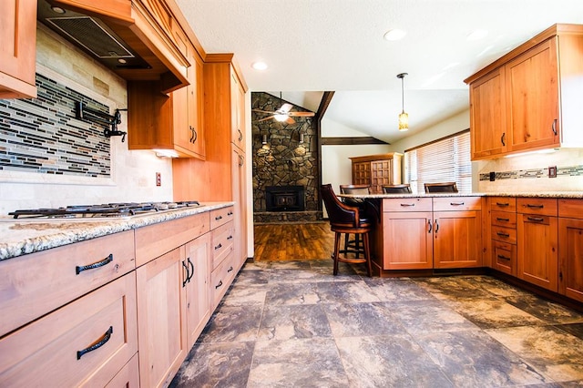 kitchen featuring tasteful backsplash, lofted ceiling with beams, pendant lighting, stainless steel gas stovetop, and custom exhaust hood