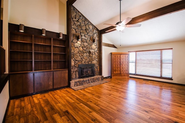 unfurnished living room featuring hardwood / wood-style floors, high vaulted ceiling, a wood stove, and ceiling fan