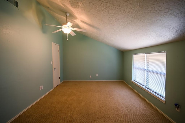 carpeted spare room with a textured ceiling, ceiling fan, and vaulted ceiling