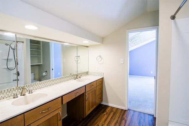 bathroom with toilet, vanity, hardwood / wood-style flooring, and vaulted ceiling