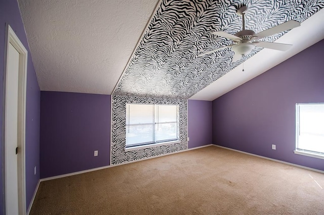 bonus room with carpet flooring, lofted ceiling, a healthy amount of sunlight, and a textured ceiling