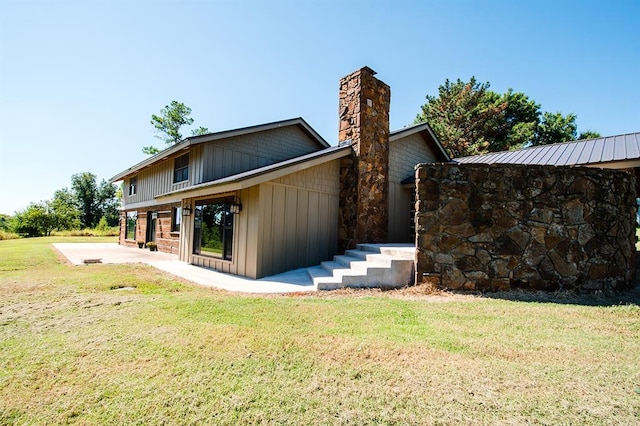 rear view of house featuring a yard