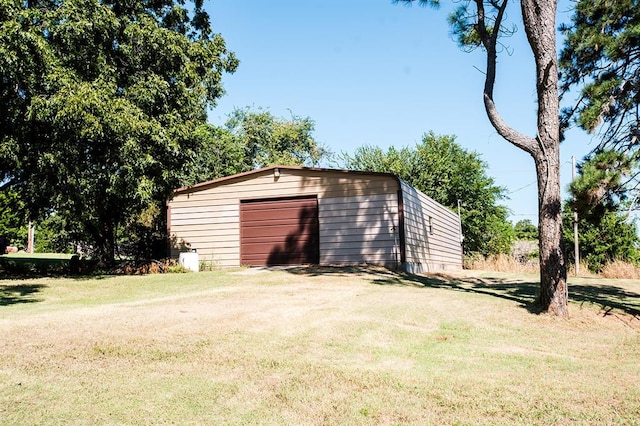 view of outdoor structure featuring a garage and a lawn