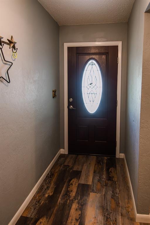 doorway to outside featuring a textured ceiling and dark hardwood / wood-style floors