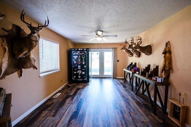 interior space with french doors, a textured ceiling, a wealth of natural light, and dark wood-type flooring