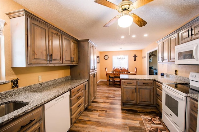 kitchen with a textured ceiling, ceiling fan with notable chandelier, white appliances, and dark wood-type flooring