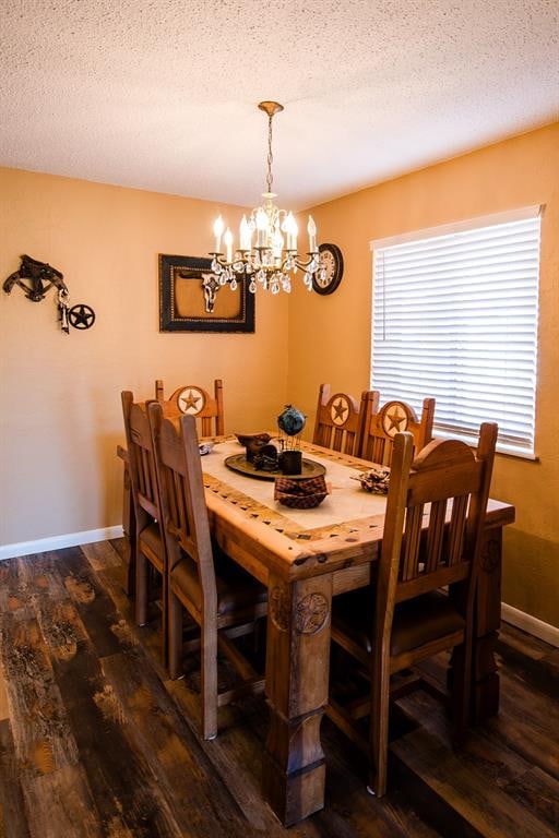 dining space with dark hardwood / wood-style flooring, a textured ceiling, and a chandelier