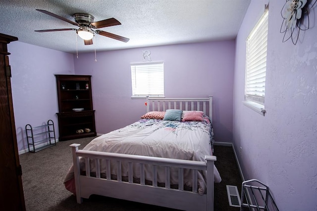 carpeted bedroom with ceiling fan and a textured ceiling