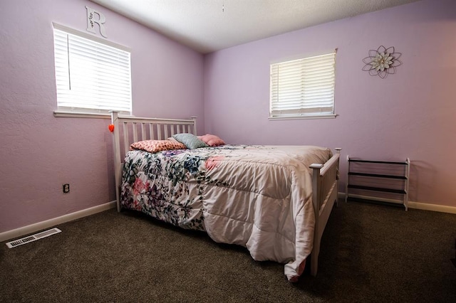 bedroom with dark colored carpet