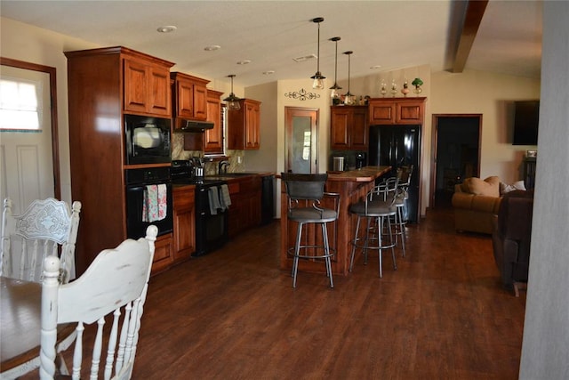 kitchen featuring lofted ceiling with beams, dark hardwood / wood-style floors, pendant lighting, a kitchen island, and black appliances