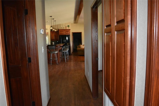 hallway featuring dark hardwood / wood-style flooring and vaulted ceiling with beams