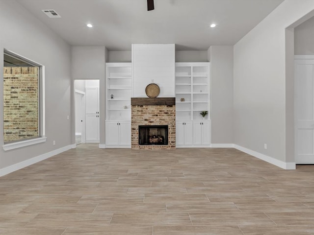 unfurnished living room featuring a fireplace, light hardwood / wood-style flooring, and ceiling fan