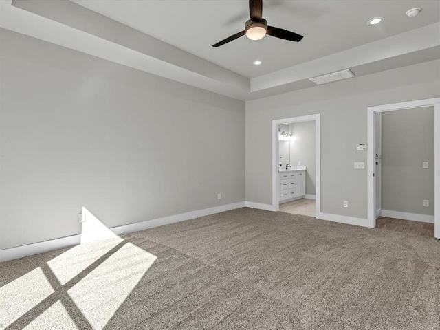 unfurnished bedroom featuring light carpet, ensuite bath, and ceiling fan