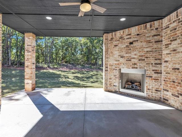 view of patio with ceiling fan and an outdoor brick fireplace